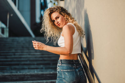 Happy woman standing against wall