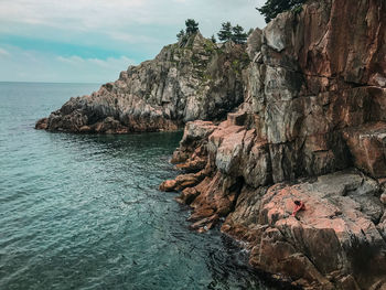 Rock formation in sea against sky