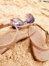 High angle view of sunglasses on sand at beach