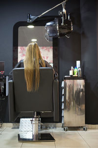 Rear view of woman sitting on table