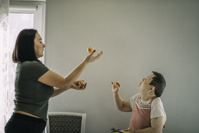 Lifestyle, education. elderly woman with down syndrome is studying in kitchen or class with teacher