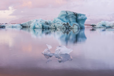 Scenic view of icebergs in sea during sunset