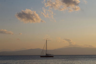 Sailboat sailing on sea against sky during sunset