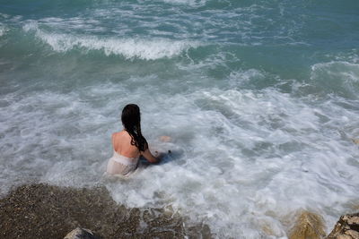 High angle view of woman sitting at beach