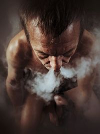 High angle view of man exhaling smoke