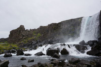 Scenic view of waterfall against sky