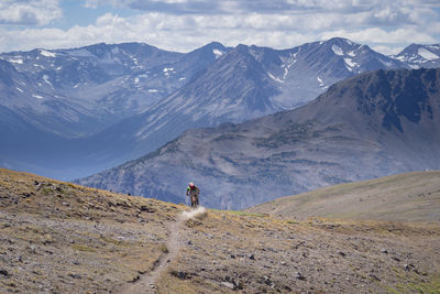 Man cycling against mountain
