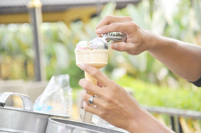 Cropped hands of vendor scoping ice cream