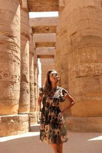 Portrait of smiling young woman standing in historical building