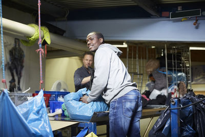 Male volunteers working at workbench in warehouse