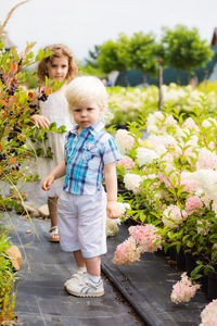 Full length of women standing on flowering plants