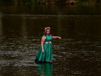 Portrait of smiling young woman standing in river