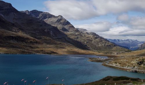 Scenic view of lake by mountains against sky