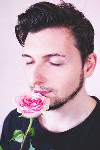 Close-up of young woman with pink rose