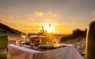 Panoramic view of restaurant by sea against sky during sunset