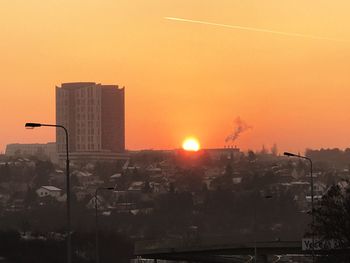 Buildings in city against sky during sunset