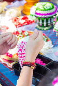 Cropped image of person holding floral garland