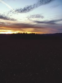 Scenic view of field against sky at sunset