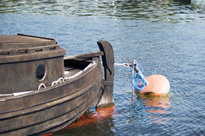 Buoy tied on boat in lake during sunny day