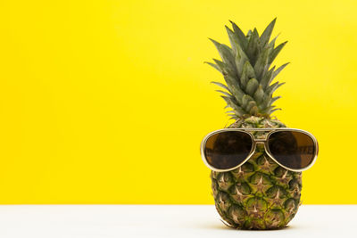 Close-up of pineapple against yellow background