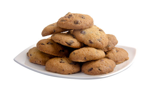 Close-up of cookies in plate against white background