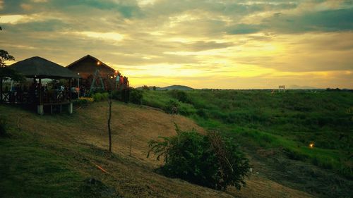 Scenic view of agricultural field against sky during sunset