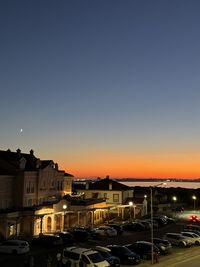 Cars on road against sky during sunset