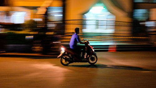 Man riding motorcycle on street in city