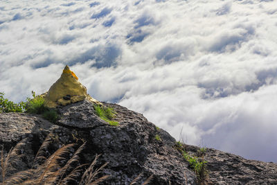 Low angle view of rocks on mountain against sky