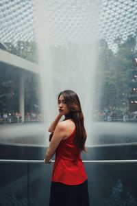 Portrait of woman standing by fountain outdoors