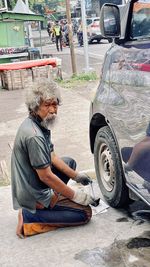 Side view of man sitting in car