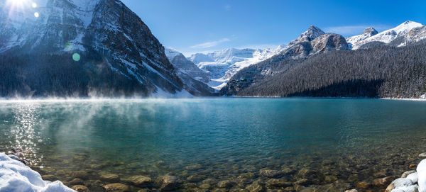 Lake louise in early winter morning. mist floating on turquoise water surface. banff national park.