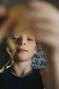 Directly above shot of boy with medal lying down at home