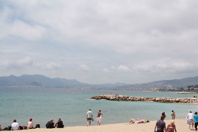 People at beach against sky