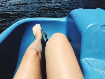 Low section of woman in pedal boat on lake