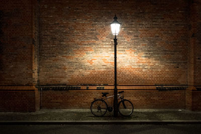 Bicycle on street light against wall