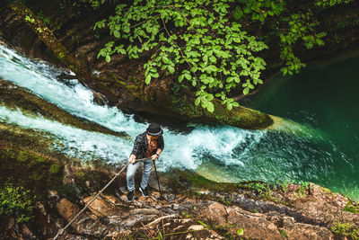 Man standing amidst plants against trees