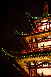 Low angle view of illuminated ferris wheel against sky at night