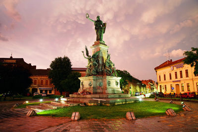 Statue in front of building against sky