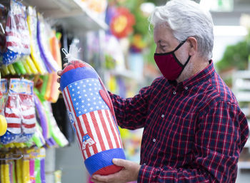 Midsection of man holding umbrella standing in store