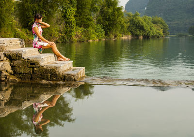 Beautiful woman sitting next to the river li in yangshuo