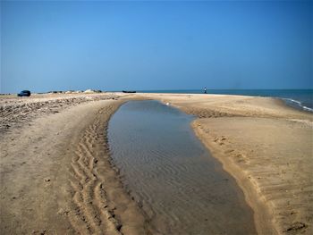 Scenic view of beach against clear blue sky