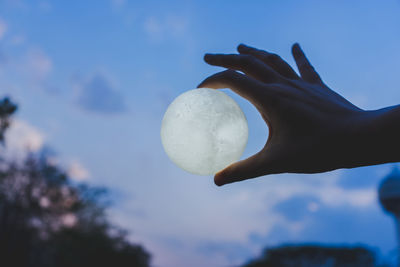 Low angle view of human hand against sky