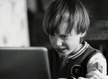 Boy crying while using laptop