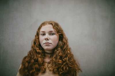 Portrait of confident teenage girl with long curly hair