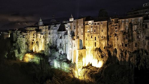 Panoramic view of illuminated cave against sky at night