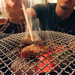 Midsection of man preparing food on barbeque grill