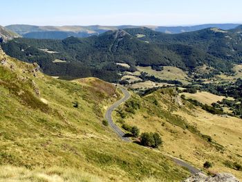 The narrow road winds through the mountain. chain of ancient volcanoes in the background. 