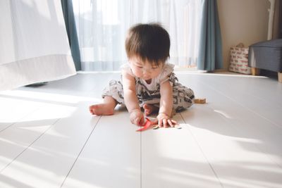 Rear view of baby boy sitting on floor