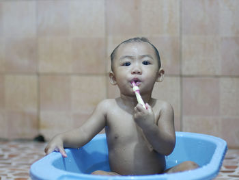 Portrait of shirtless boy in bathroom